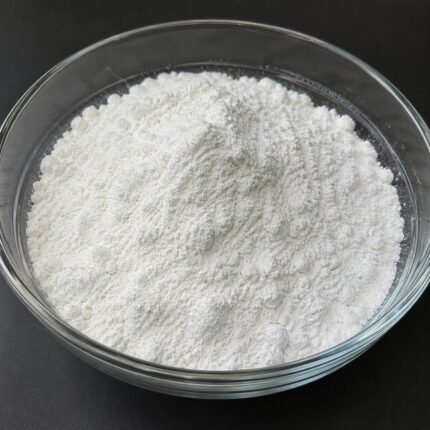 Allantoin fine white crystalline powder in a glass bowl used for soothing and skin-repair cosmetic formulations.