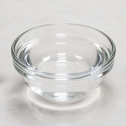 Cetiol CC clear lightweight emollient liquid in a glass container used for smooth, non-greasy cosmetic formulations.