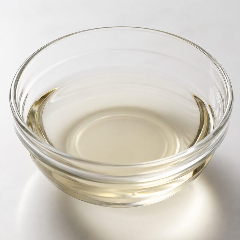 PEG-12 Dimethicone clear lightweight silicone liquid in a glass container used as an emulsifier and conditioning agent in cosmetic formulations.