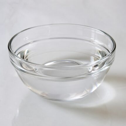 Isopropyl Myristate (IPM) clear lightweight oil in a glass bottle used as an emollient in cosmetic formulations.