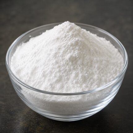 Niacinamide fine white crystalline powder in a glass bowl used for brightening and skincare formulations.