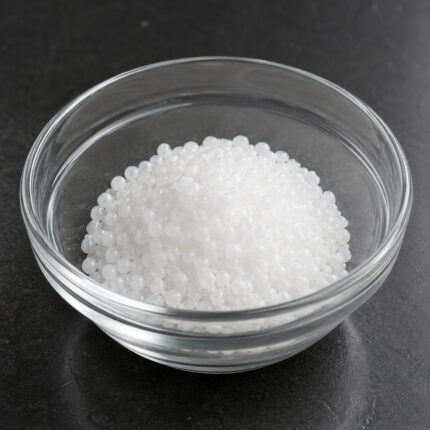 Cetearyl Alcohol white waxy flakes or pellets in glass container used as emulsifier and thickening agent in cosmetic formulations