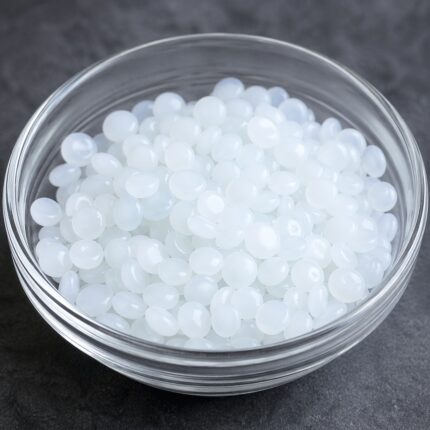 BTMS 50 white waxy flakes in a container, commonly used as a conditioning emulsifier in hair care and cosmetic formulations.
