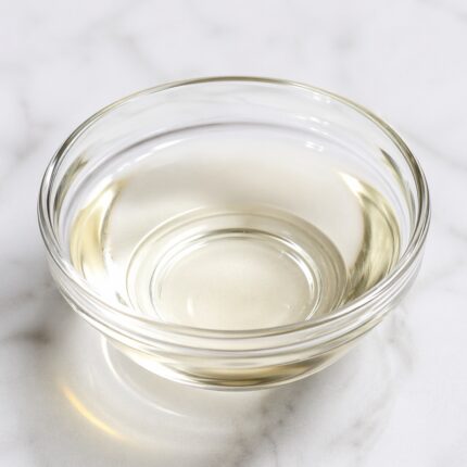 Dimethyl isosorbide clear, colorless liquid in a glass container, commonly used as a solvent and penetration enhancer in cosmetic and pharmaceutical formulations.