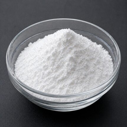 Fine white free-flowing powder of DryFlo PC in a glass bowl, smooth texture and cosmetic-grade appearance.