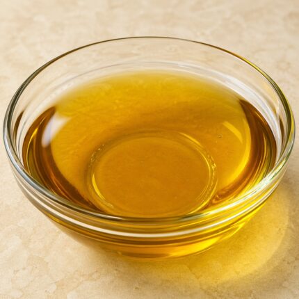 Pale yellow to light orange oily liquid of Retinyl palmitate in a clear glass container, smooth and glossy appearance.